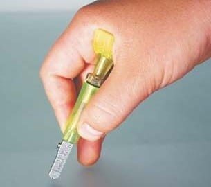 Nóż do szkła olejowy podkciukowy TOYO TC9P trzymany w dłoni podczas cięcia. jpg