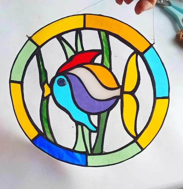 Zawieszka witrażowa Rybka wykonana metodą Tiffany, kolorowe szkło w czarnej patynie, rękodzieło, wymiary ok. 25 × 24 cm, dekoracja do okna na białym tle.jpg