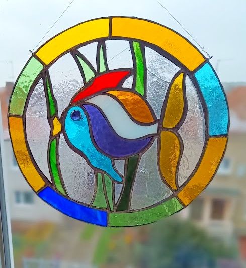 Zawieszka witrażowa Rybka wykonana metodą Tiffany, kolorowe szkło w czarnej patynie, rękodzieło, wymiary ok. 25 × 24 cm, dekoracja do okna na tle okna.jpg